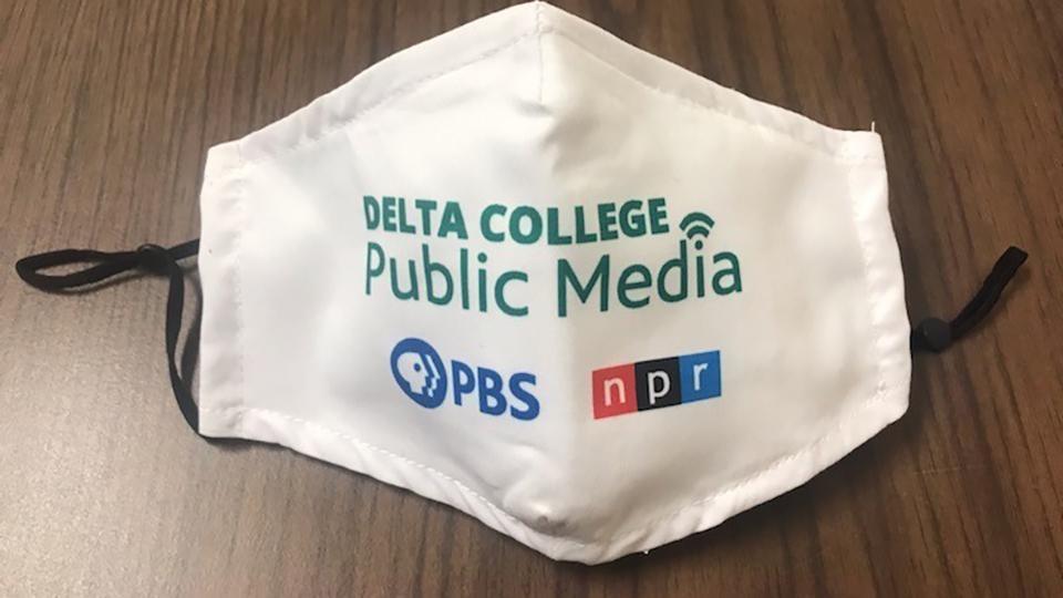 White facemask with adjustable straps and Delta College Public Media logo.