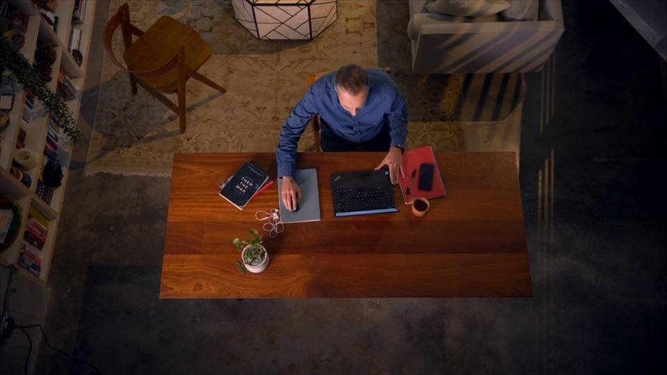 An overhead view of a man working on a laptop.