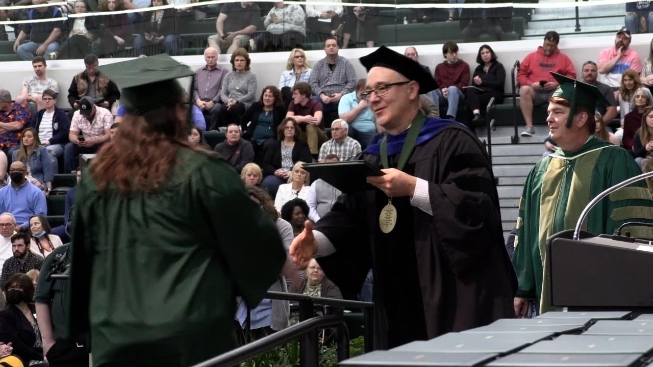 Delta College President Gavin shakes a graduate's hand.