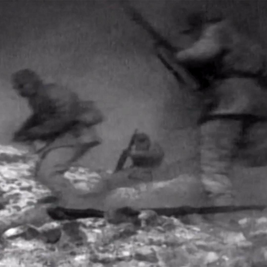 Soldiers running across a battlefield in the Korean War.