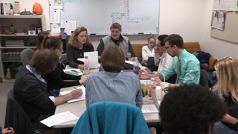 Delta Collegiate writers sit around a table.