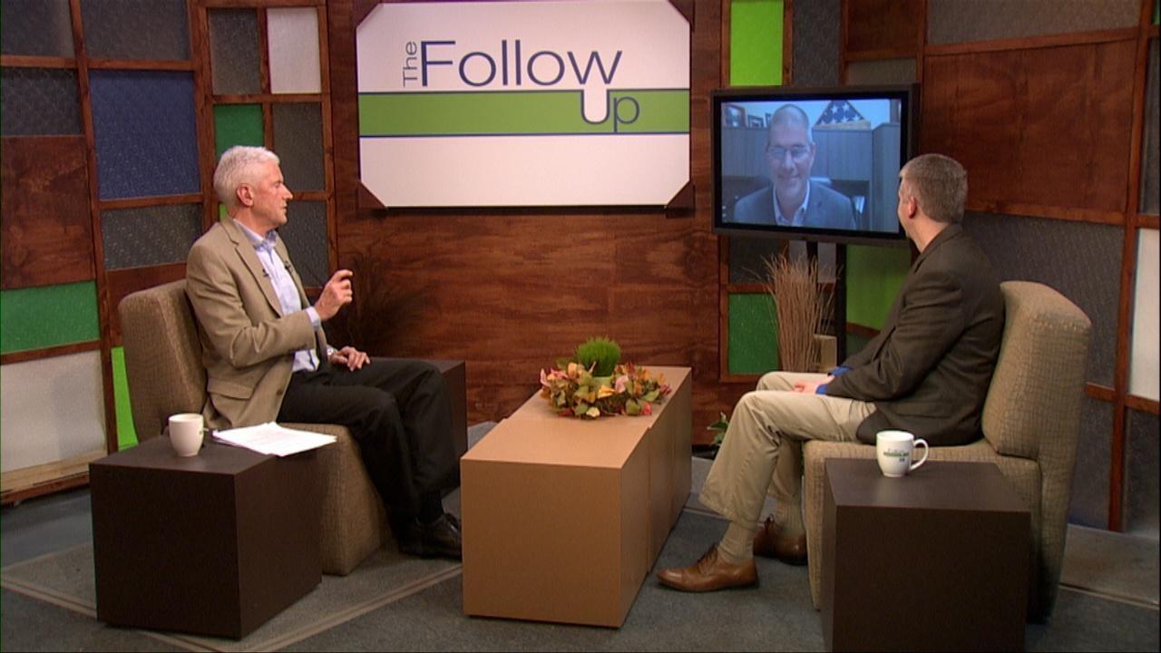 Host Mike Redford with a guest on set and a guest on a monitor.