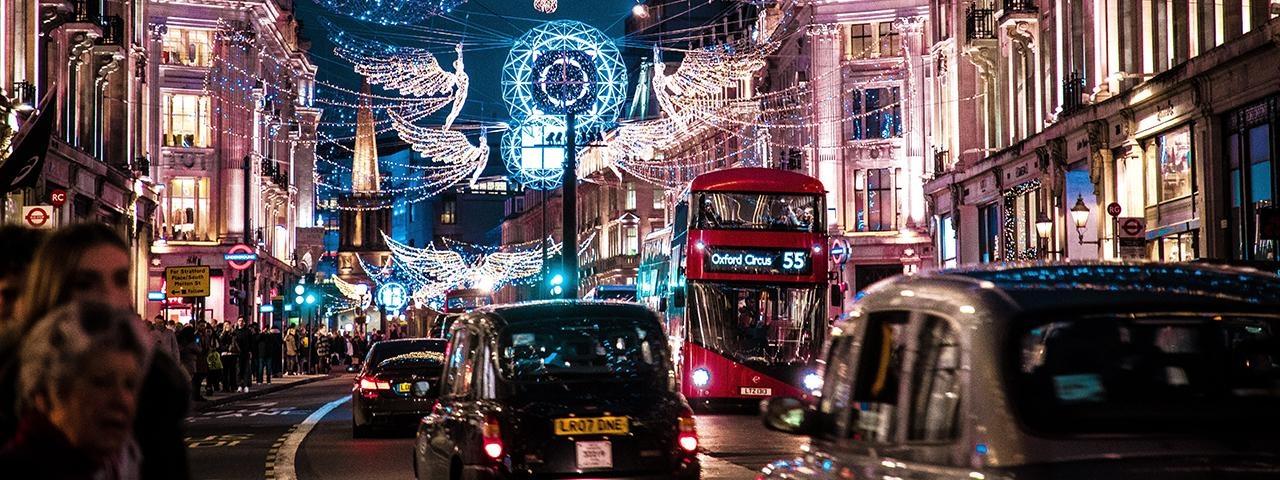 Lights, including Christmas angels, over a busy London street.