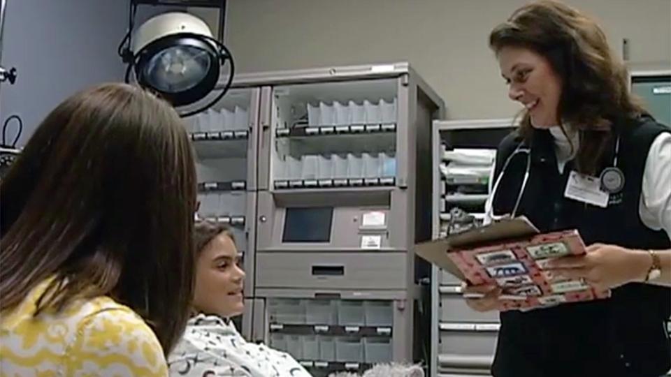 A woman doctor talks to a girl in a hospital bed and her mother.