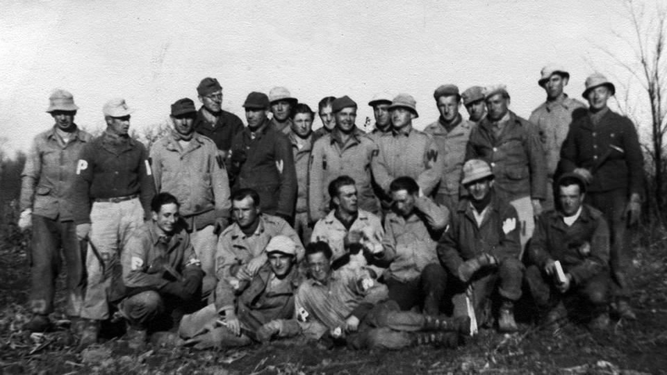 A group of POWs posing in a field.