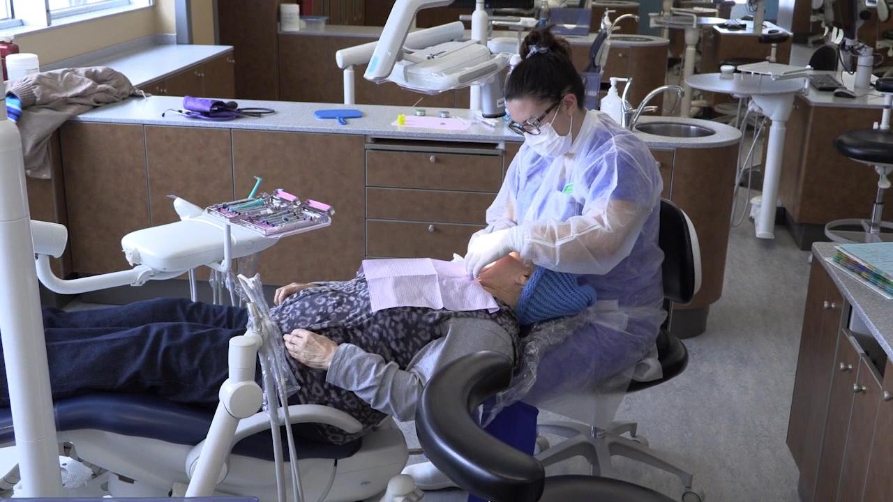 A dental hygienist student practices cleaning teeth.