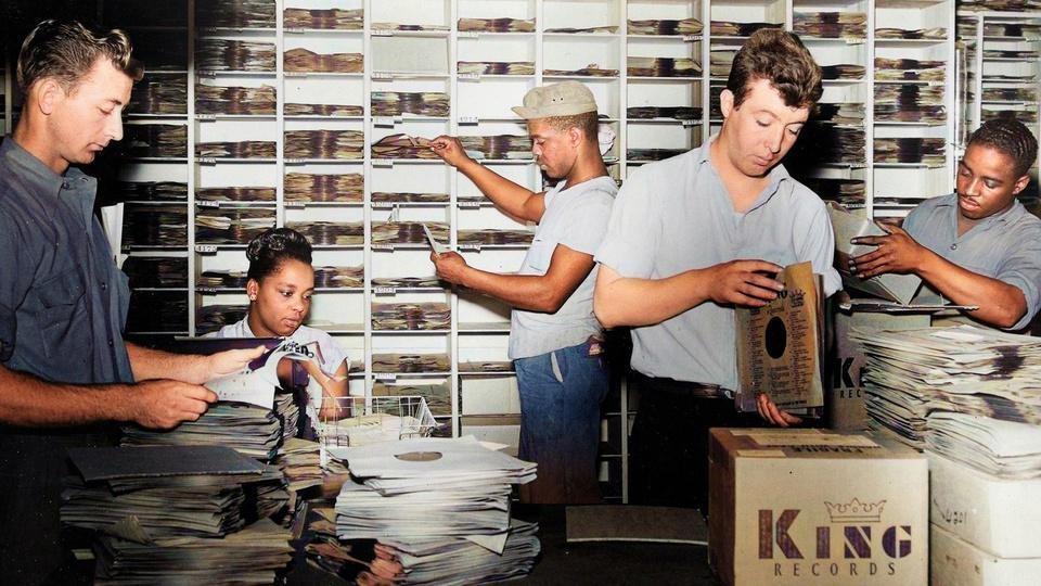 Five people stuffing record sleeves.