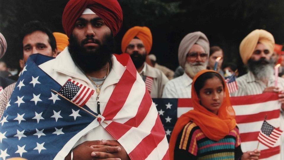 People wearing turbans and holding American flags.