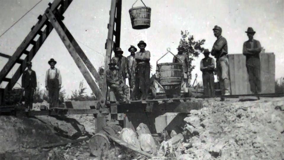 Coal miners stand at the top of a mine.