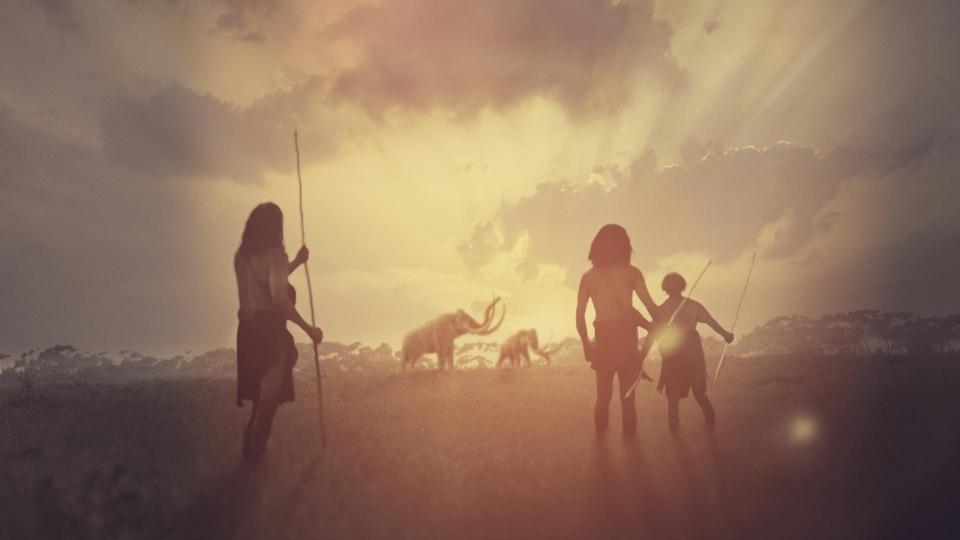 Ancient humans with spears looking at mammoths in the distance.