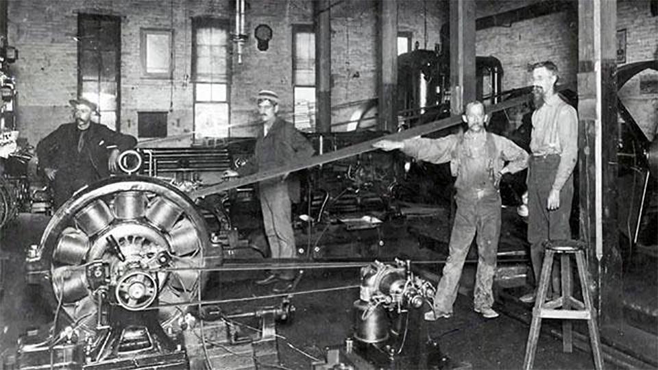 Men work in a 19th-century factory.