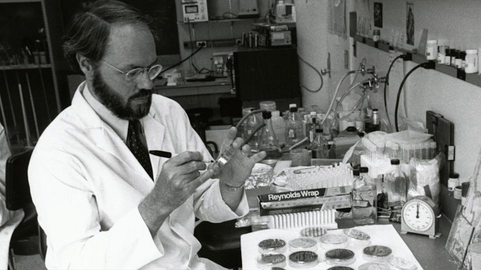 Phil Sharp labeling a petri dish in a lab.