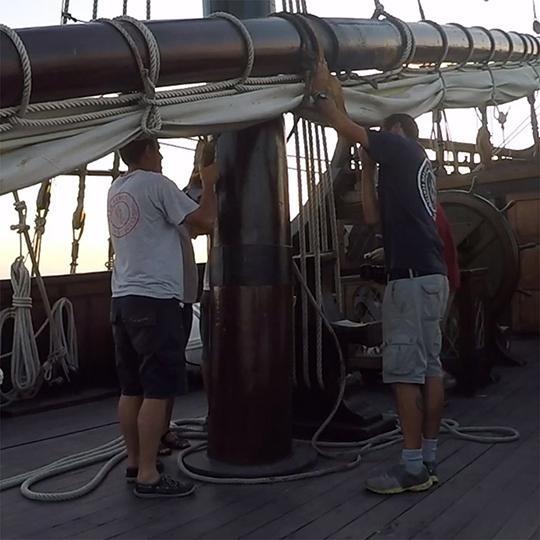 El Galeon crew members work on a sail.