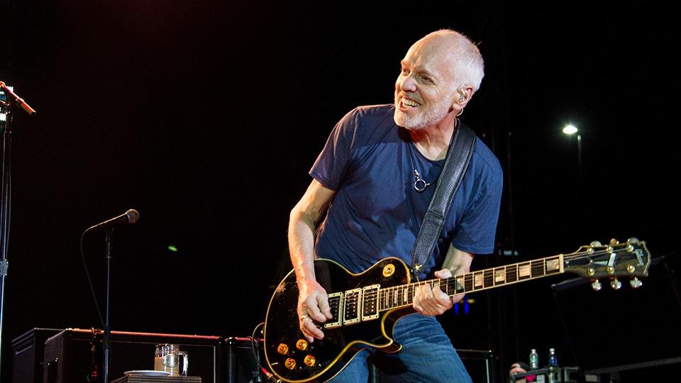 Peter Frampton playing guitar on stage.