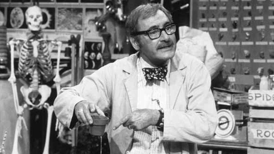George Fiscbeck in a lab coat in a science classroom on the show "What's New?"