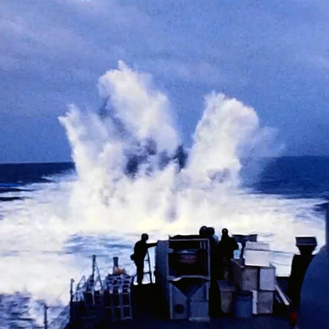 The Edson sets off a depth charge in the ocean.