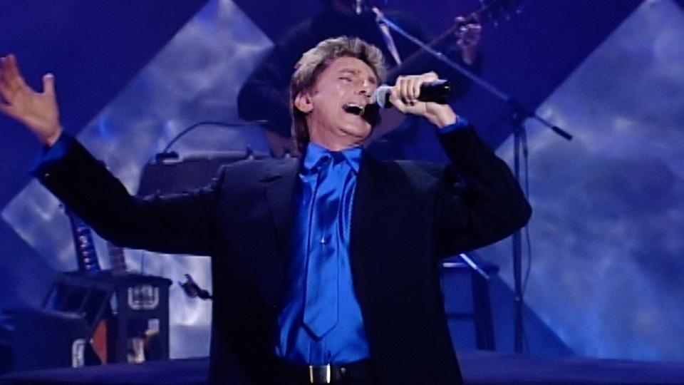Barry Manilow performing onstage in 1996.