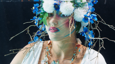 Woman wearing a floral headdress. She is underwater