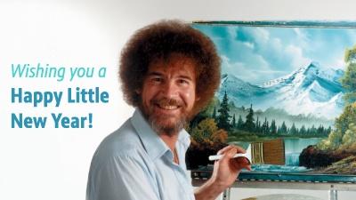 Bob Ross facing the viewer. He's holding a paint brush and there's a mountain landscape canvas behind him