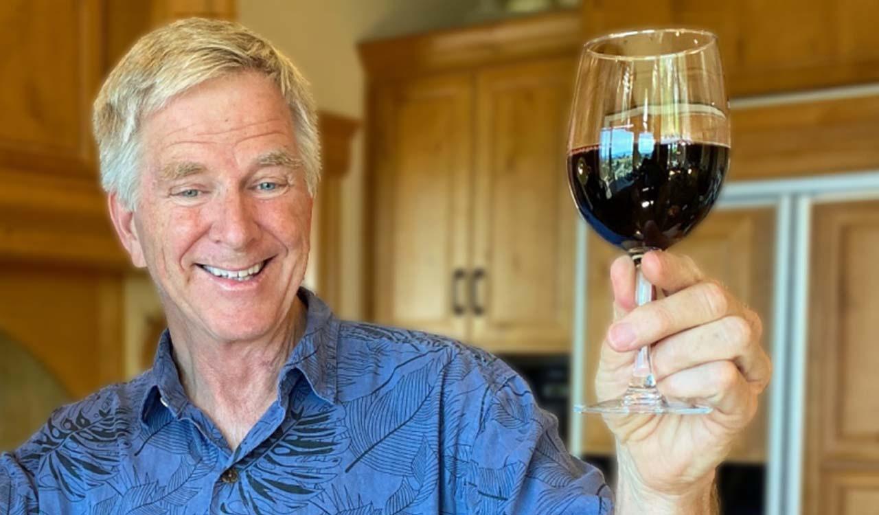 Rick Steves holding a glass of red wine