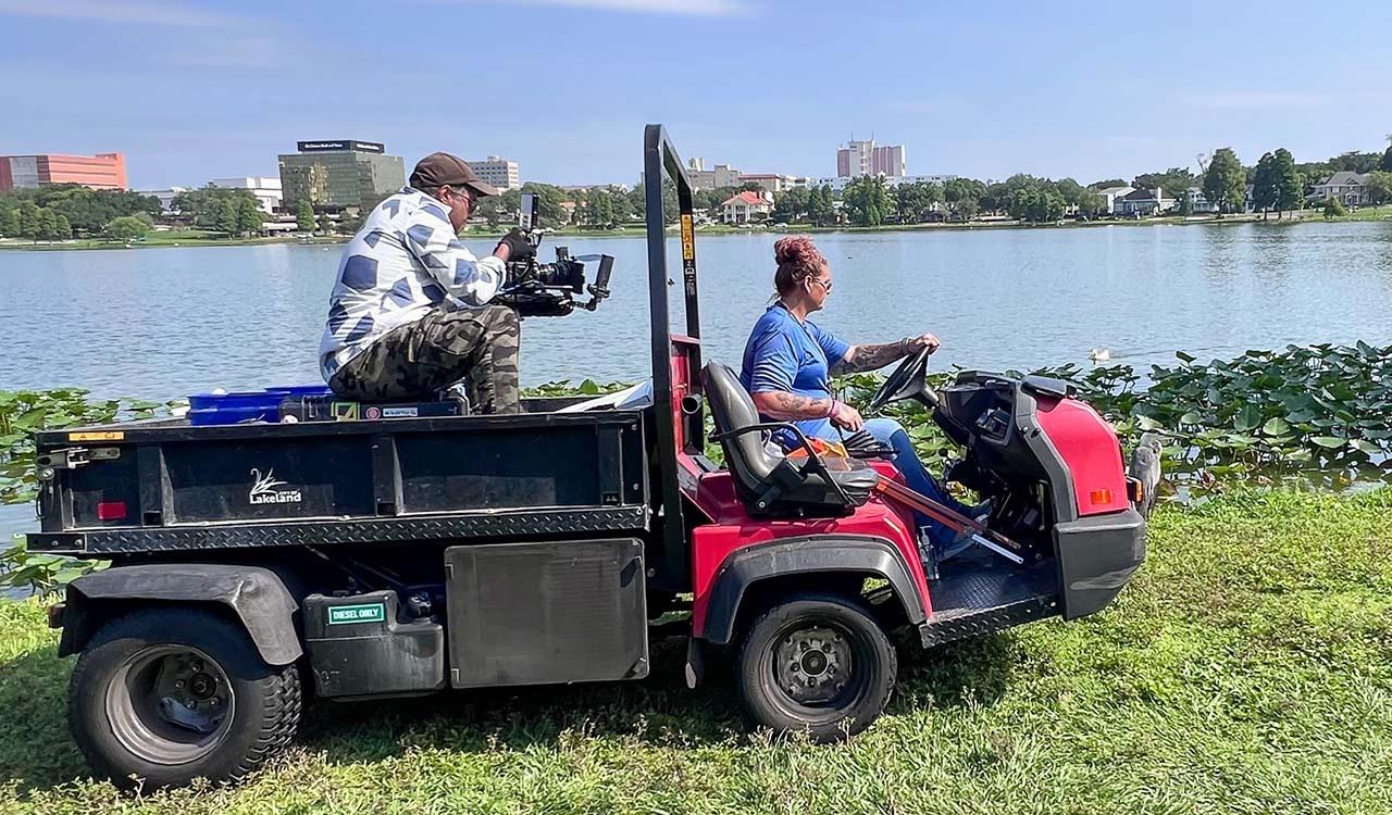 Cameraman on a tractor being driven on the lakeshore