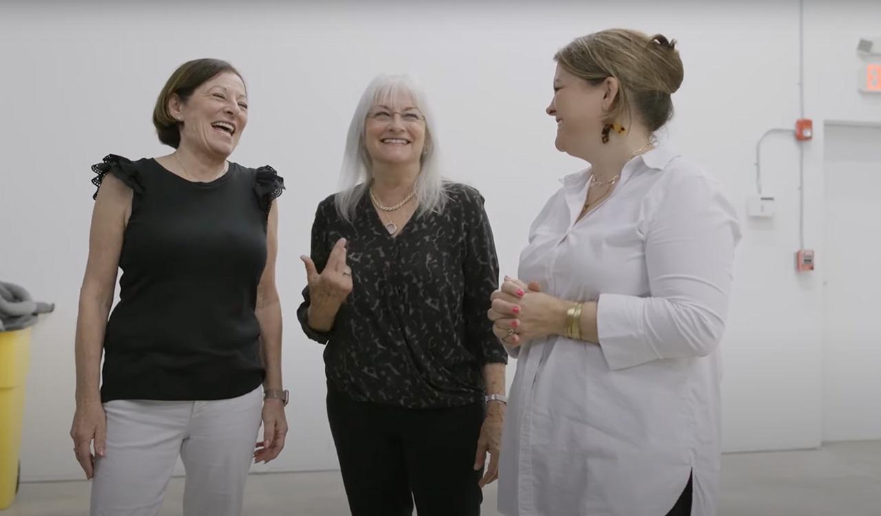 Three woman laughing in a white room