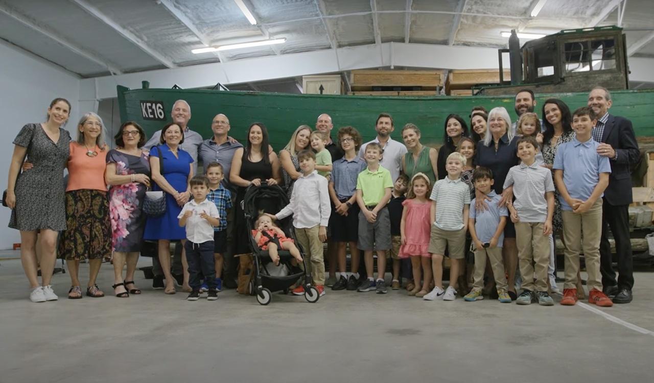 Families impacted by the Danish Rescue in front of the boat that rescued their families