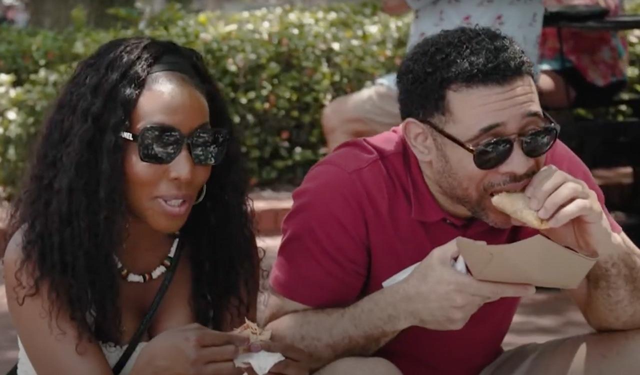 Two people enjoying cuban sandwiches outdoors