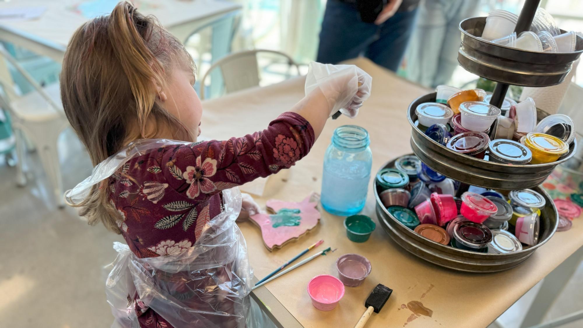 A child plays with paint at an event