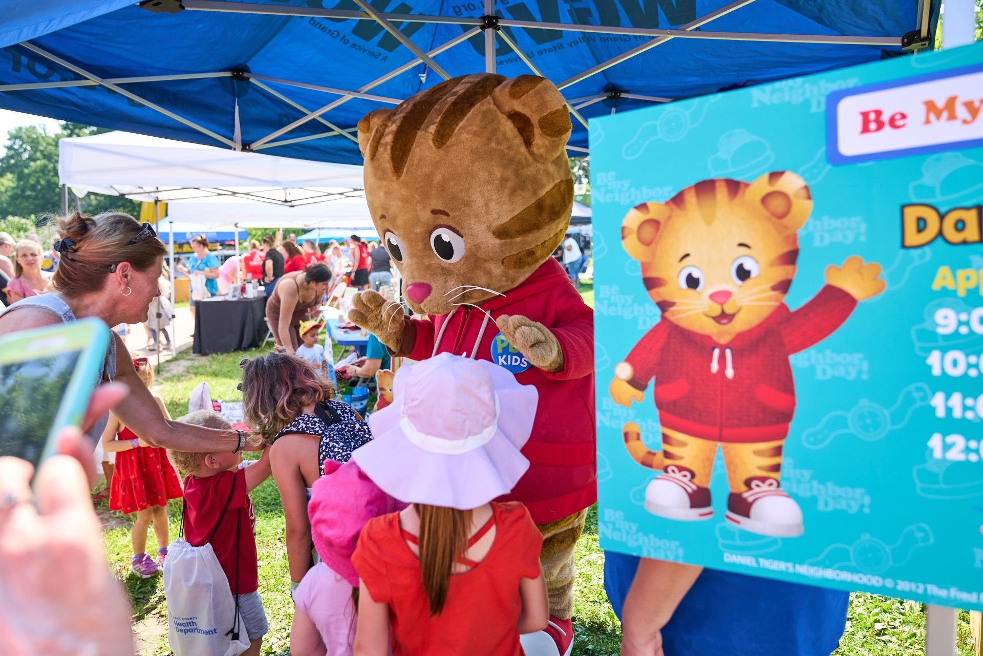 Daniel Tiger greets families at Be My Neighbor Day