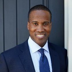john james wearing a suit and smiling at the viewer