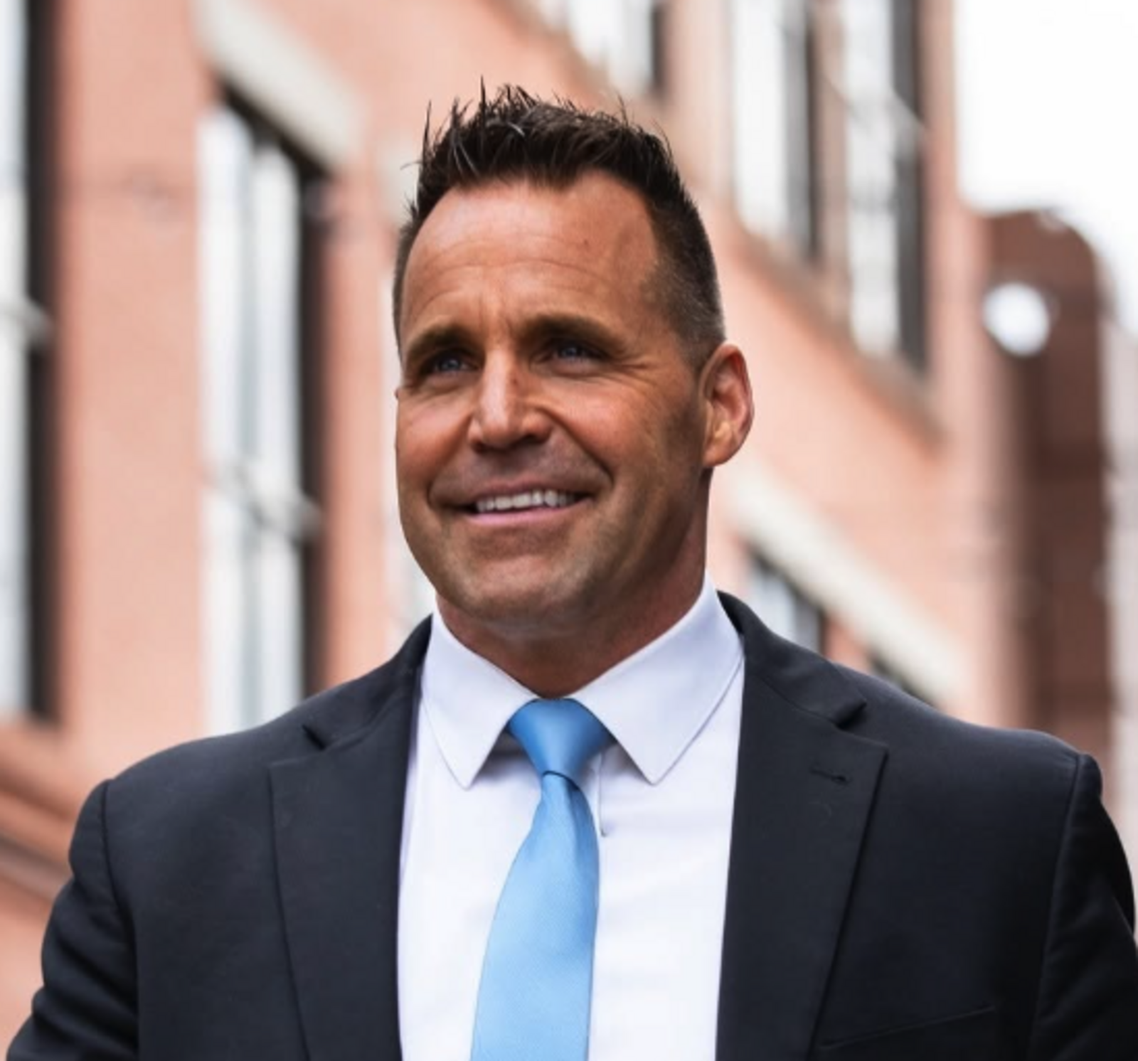 christopher robert swanson wearing a suit and smiling while walking down the street