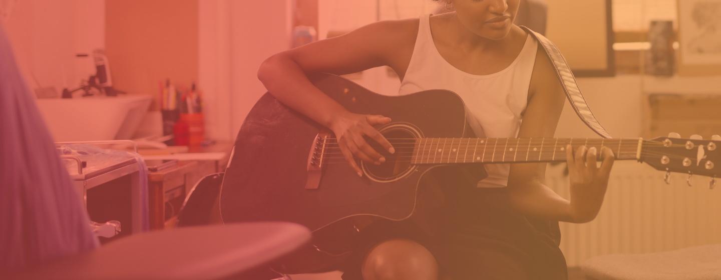 Woman playing the guitar in her room