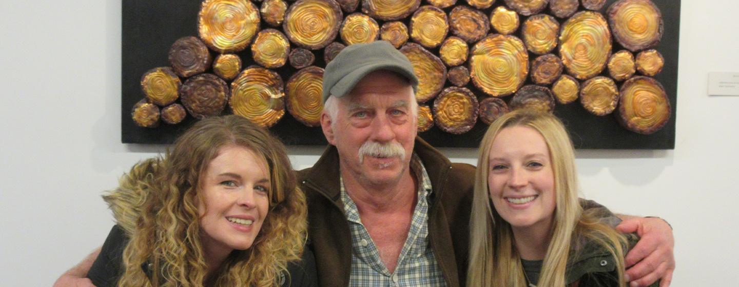 Male artist with his two daughters at a gallery
