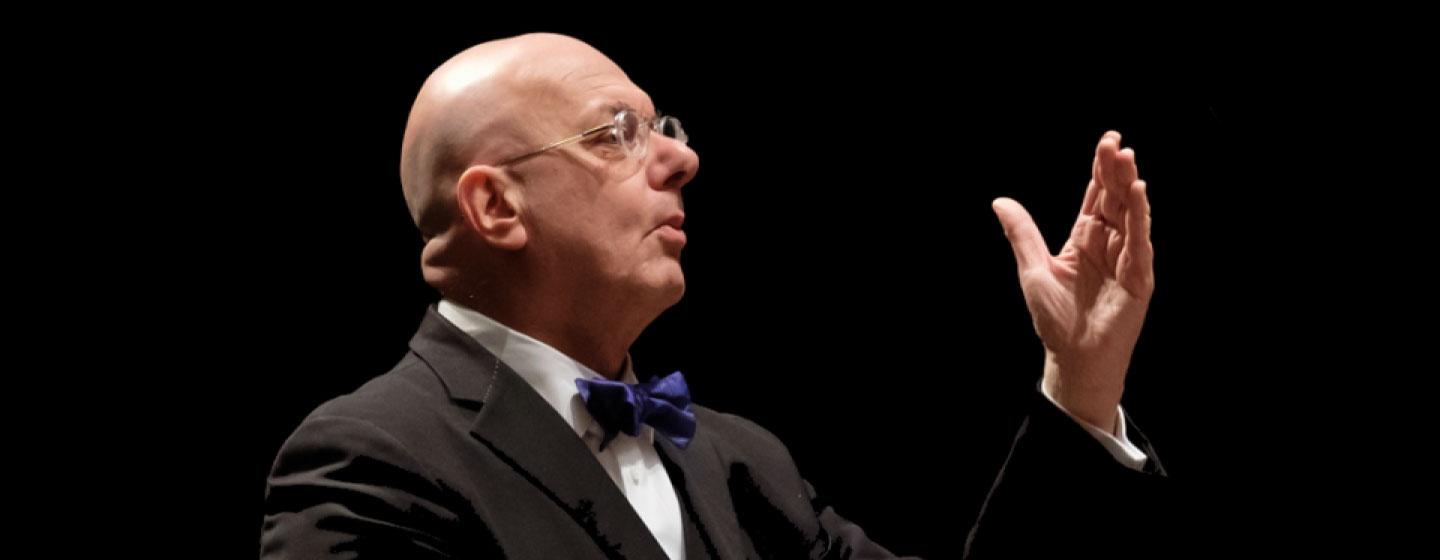 Leon Botstein, Music Director of TON (The Orchestra Now). He wears a suit featuring a purple bow tie while conducting an orchestra