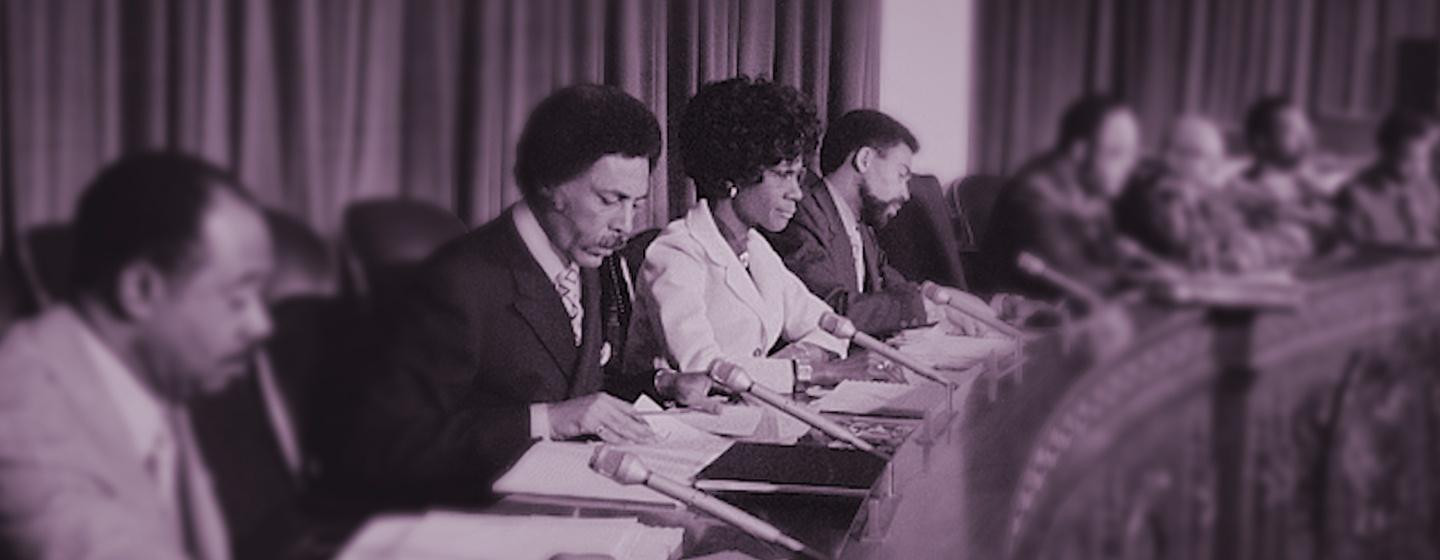 Congresswoman Shirley Chisholm sits attentively at a congressional hearing.