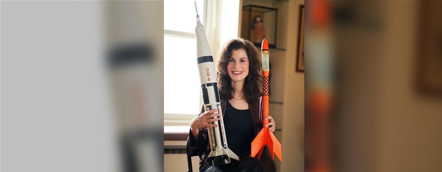 A photo of Sharon Isbin holding model rockets.