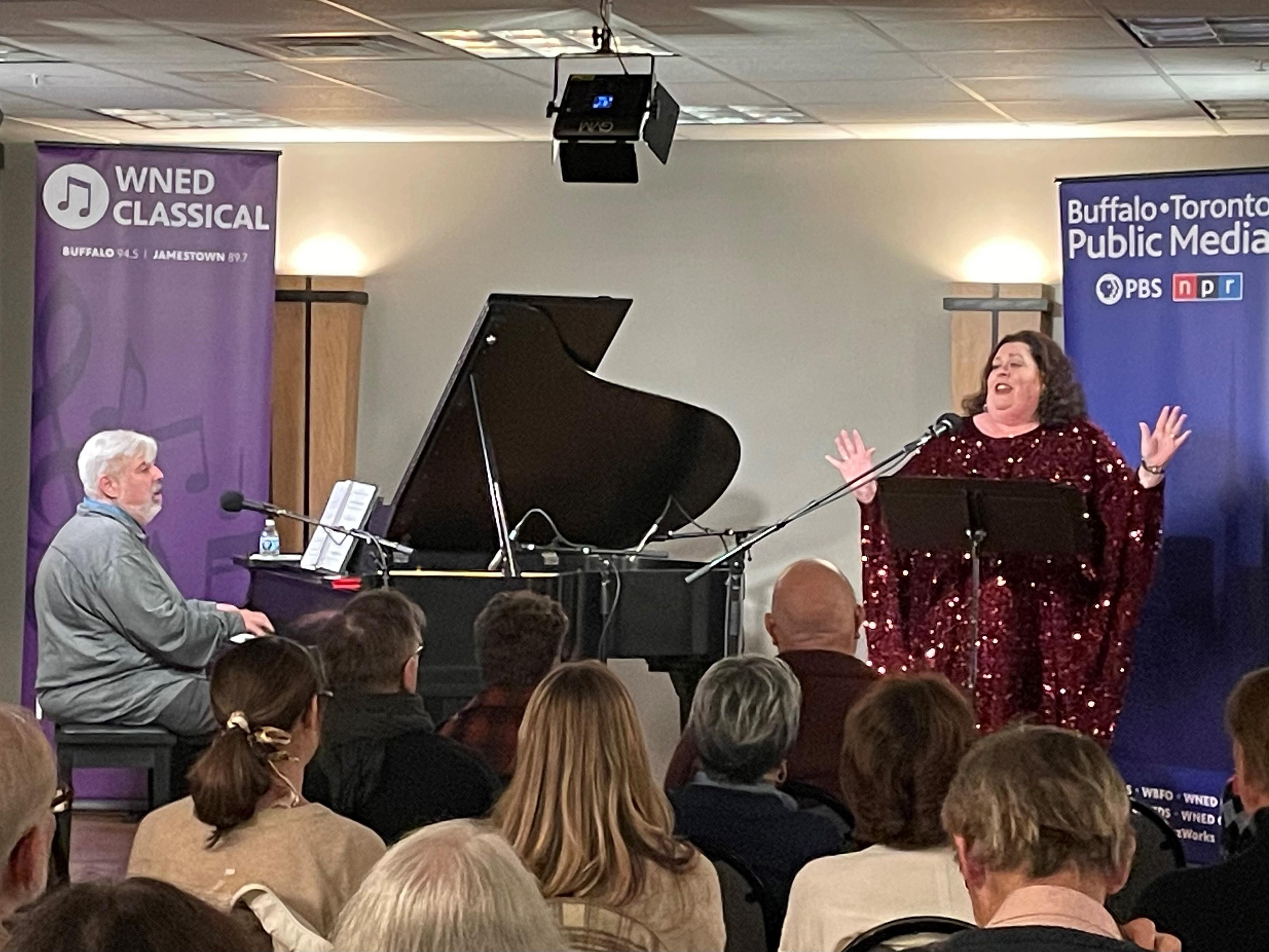 a man playing the piano and a woman singing onstage in the WNED Classical Performance space