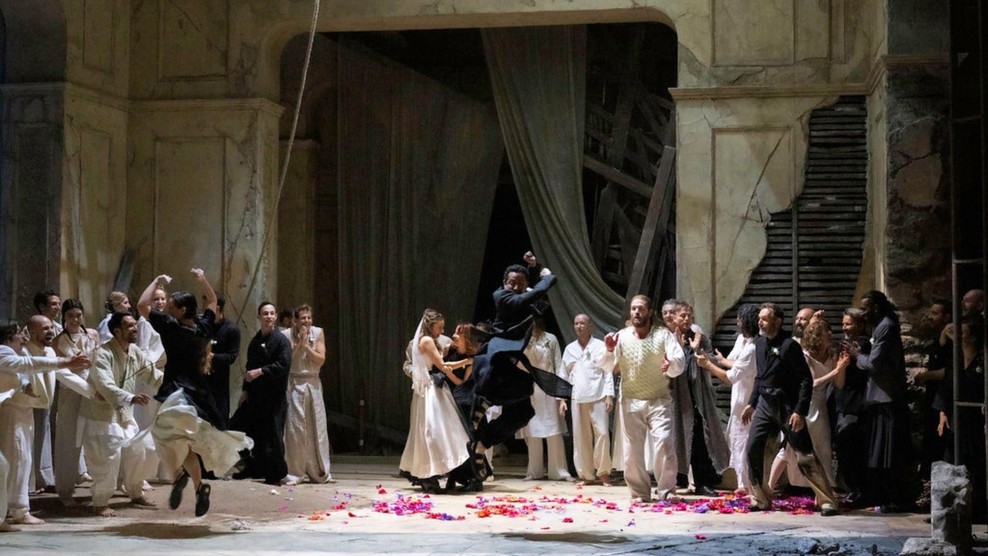 A scene from Samson where a man is dancing in the air over colorful petals, surrounded by others