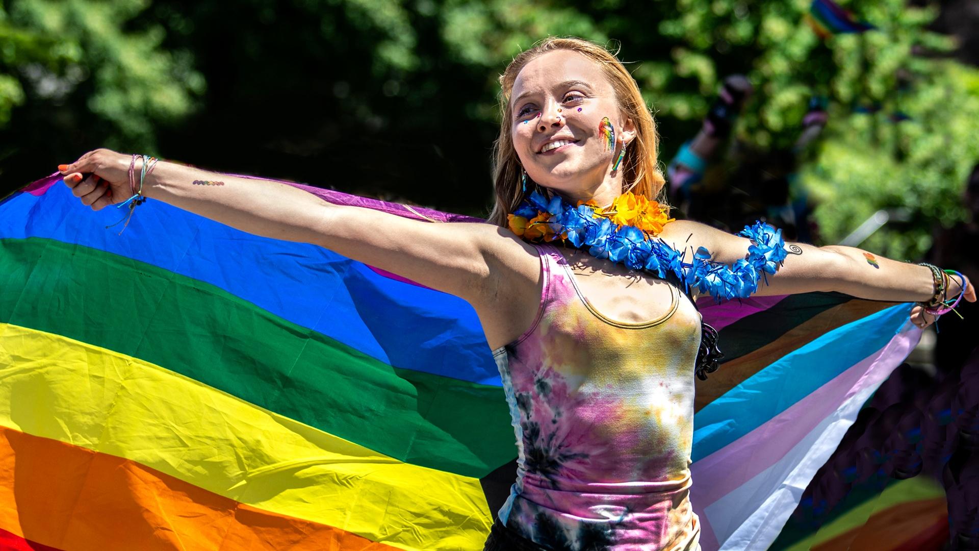 young woman draped in a rainbow flag