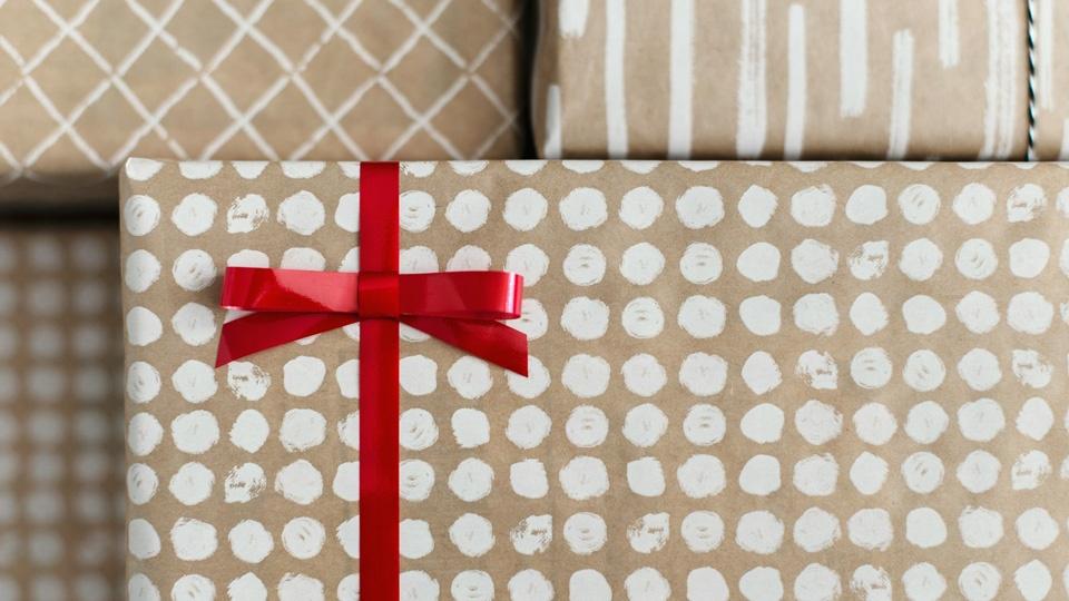 Boxes wrapped in tan and white paper with red bows