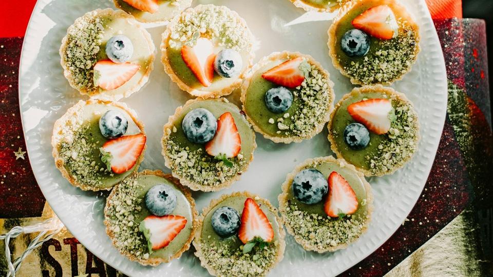 mini green pies topped with strawberries and blueberries