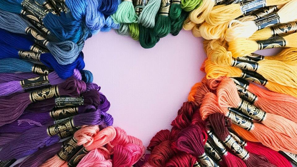 Colored bundles of embroidery thread arranged together to form a heart shape