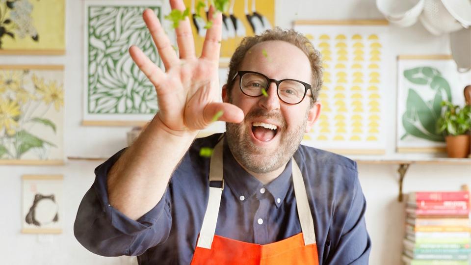 Chef Joel Gamoran playfully throwing lettuce at the camera