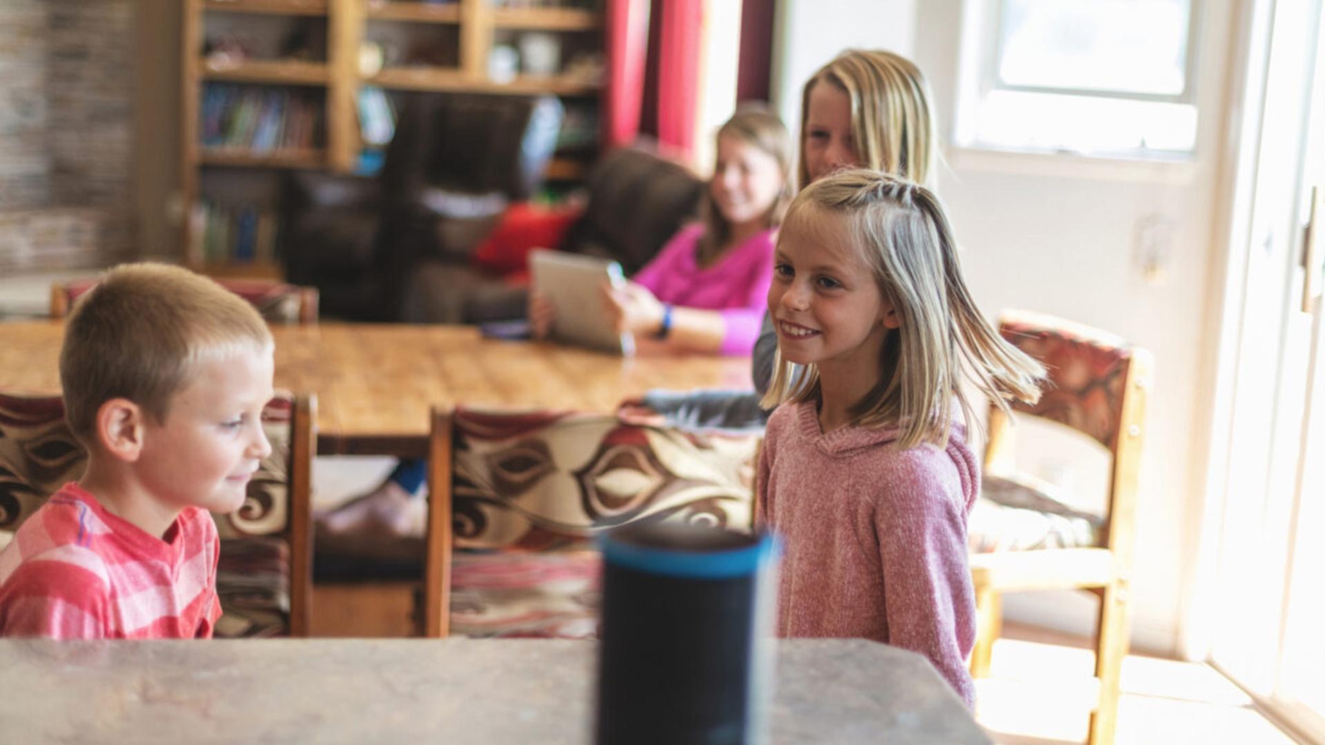 family with young children listening to a smart speaker