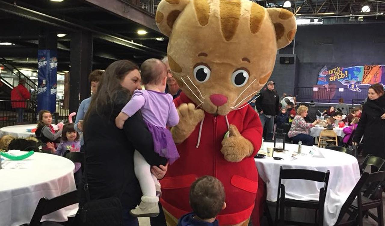 Daniel Tiger greets a young fan at the Character Breakfast