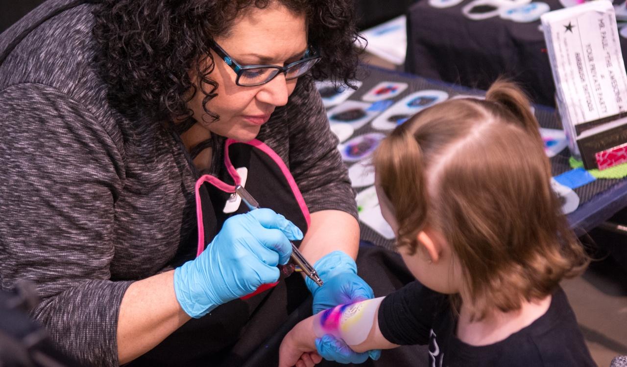 Young girl getting an airbrush tattoo during WNED's Kid Fest