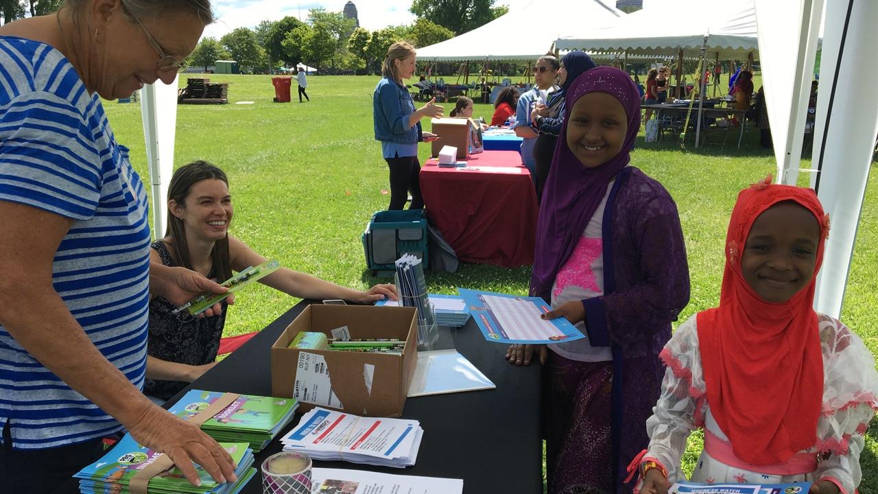 young girls taking home some PBS KIDS activities from the WNED | WBFO booth