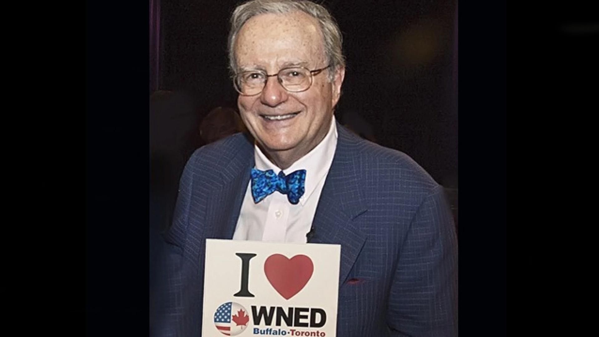 Mark Russell holding a sign that says "I heart WNED"
