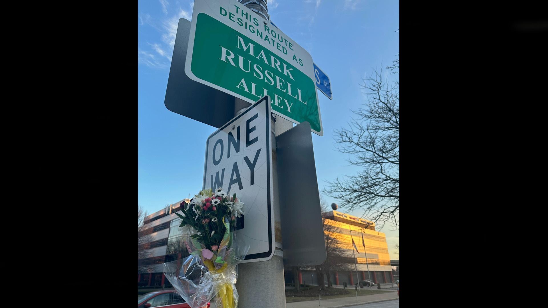 flowers left at street sign for "Mark Russell Alley" in front of Buffalo Toronto Public Media